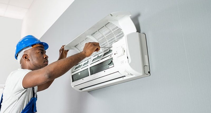 Technician tinkering with an AC